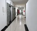 Pasillo moderno con ascensores y salida acristalada.webp